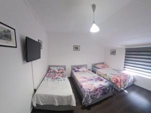 two twin beds in a room with a tv at Hostel FM in Mostar