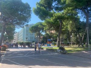 a group of people walking in a park with trees at Sunny Home, appartamento in centro e vicino alla spiaggia in Grado