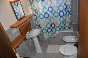 a bathroom with a sink and a toilet and a shower curtain at Cabaña Maitén in San Carlos de Bariloche