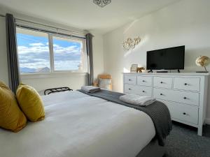 1 dormitorio con 1 cama con TV y vestidor en Dalriach Apartment, en Oban