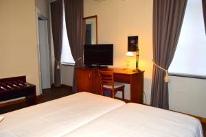 a hotel room with a bed and a television at Oranje City Hotel in Diest