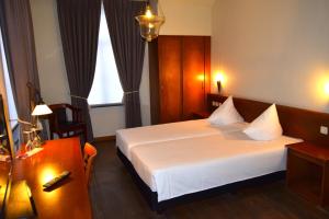 a hotel room with a bed and a desk at Oranje City Hotel in Diest