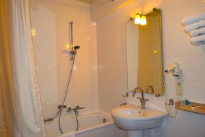 a bathroom with a tub and a sink and a shower at Oranje City Hotel in Diest