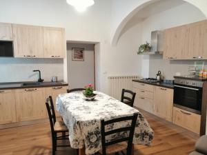 a kitchen with a table with a vase of flowers on it at La Dimora degli Olivi in Torrita di Siena