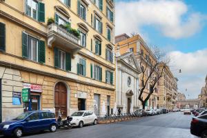 una calle de la ciudad con coches estacionados frente a los edificios en Fabrizio's Rooms en Roma