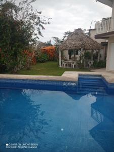 een zwembad voor een huis met een prieel bij Villa kosniin in Tecolutla