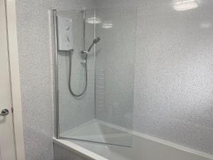 a shower with a glass door in a bathroom at Dalriach Apartment in Oban