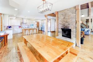 eine Küche und ein Wohnzimmer mit einem Holztisch und einem Kamin in der Unterkunft Lucille 109 in Blue Mountains