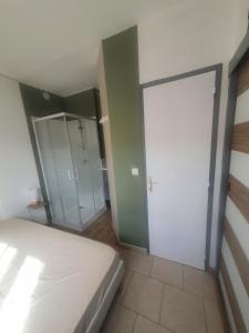 sypialnia z łóżkiem i przesuwnymi drzwiami w obiekcie Apartment Saint Saens w mieście Marseillan
