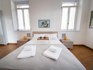 a large white bed in a room with windows at VILLA SILVIA-by Home Sitter Como in Como