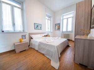 a white bedroom with a bed and two windows at VILLA SILVIA-by Home Sitter Como in Como