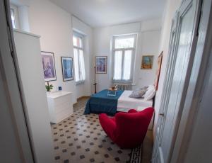 a bedroom with a bed and a red chair at VILLA SILVIA-by Home Sitter Como in Como