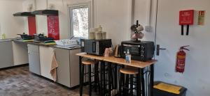 a kitchen with a microwave and a counter with stools at Birchwood Guest Lodge in Balmaha