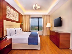 una camera con un grande letto e una TV di Holiday Inn Cochin, an IHG Hotel a Cochin