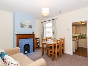 een woonkamer met een tafel en een open haard bij Seaside Retreat in Lowestoft