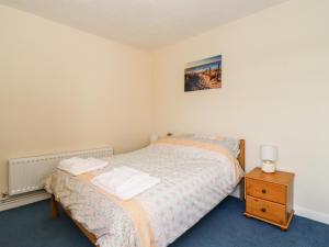 a small bedroom with a bed and a night stand at Seaside Retreat in Lowestoft