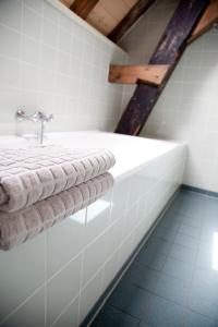 a bathroom with white towels on a bath tub at Gelkingehof Aparthotel in Groningen +46 photos