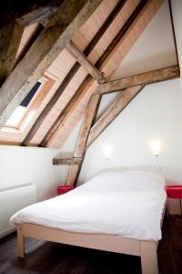 a bedroom with a white bed in the attic at Gelkingehof Aparthotel in Groningen