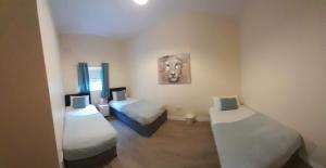 a room with two beds and a painting on the wall at Delphi Cottage in Ashbourne