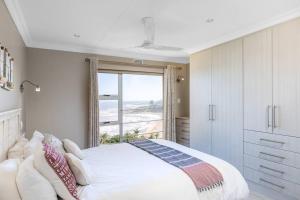 a bedroom with a bed and a large window at Ramsgate Palms Accommodation in Ramsgate