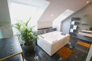 a bathroom with a white tub and a large window at Hotel Vienna beim Prater in Vienna