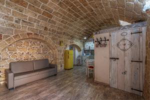 a living room with a couch and a brick wall at Le casette di Nardò in Nardò