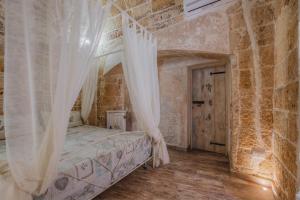 a bedroom with a bed with a mosquito net at Le casette di Nardò in Nardò