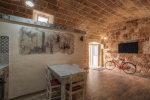 ナルドにあるLe casette di Nardòのテーブル付きの部屋、壁に自転車を設置した部屋