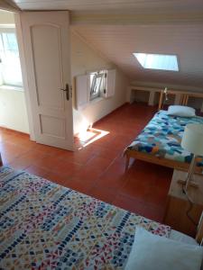 a bedroom with a bed, a desk, and a window at Hakuna Matata Hostel in Zambujeira do Mar