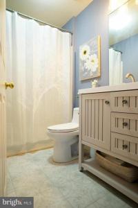 a bathroom with a toilet and a shower curtain at 5BRwithBand&Piano setup Private Gym Theater&Entry at Cherry Hill in Cherry Hill