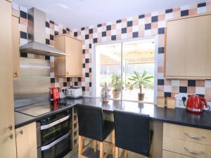 a kitchen with a black counter top and a window at Woodview in Norwich