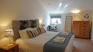 Un dormitorio con una cama grande con toallas. en Merchants Rest, en Dartmouth