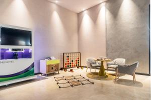 a living room filled with furniture and a tv at Hotel Novotel Sevilla in Seville