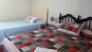 a bedroom with two beds and a quilt at Hospedaje Kelita in Moquegua