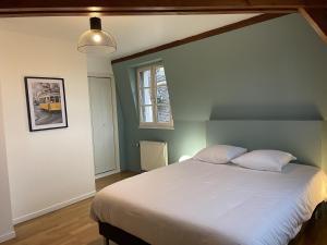 - une chambre avec un grand lit blanc et une fenêtre dans l'établissement Appartement le Saint-Nicolas Auxerre Les Quais, à Auxerre