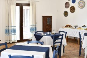 a dining room with blue and white tables and chairs at Tenute Efis in Galtellì
