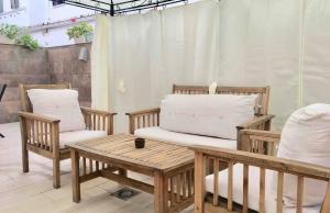 eine Terrasse mit 2 Stühlen und einem Tisch mit Kissen in der Unterkunft Apartamento Los Naranjos de Santa Justa in Sevilla