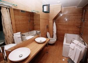 a bathroom with two sinks and a toilet and a tub at Park Hotel Sandanski in Sandanski +29 photos