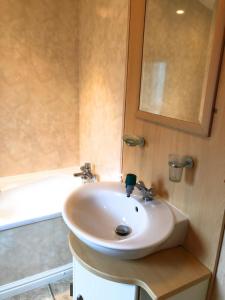 a bathroom with a white sink and a bath tub at Gold Caravan in Harrietsfield