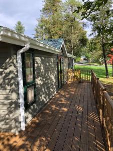 una terrazza in legno accanto a una casa con recinzione di Gold Caravan a Harrietsfield