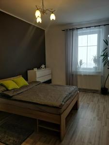 Niezapomniany widok في كارباش: غرفة نوم بسرير ومخدات صفراء ونافذة