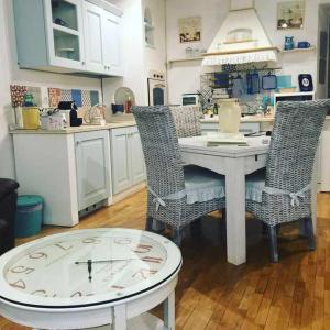 eine Küche mit einem Tisch mit Stühlen und einer Uhr in der Unterkunft Appartamento familiare nel cuore di Roma in Rom