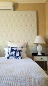 a bedroom with a white bed with a large headboard at Black Diamond B&B Guesthouse in Upington