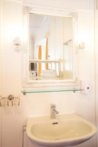 a bathroom with a white sink and a mirror at Zunfthaus zur Rebleuten in Chur +37 photos