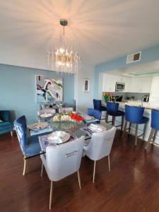 a dining room with a table and blue chairs at Oceanfront lux condo in Long Beach