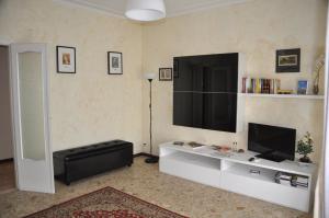 una sala de estar con TV y un centro de entretenimiento blanco en Apartment Montebello, en Parma