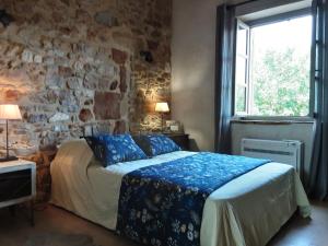 a bedroom with a bed and a stone wall at La maison de Jérôme et Virginie in Aigaliers