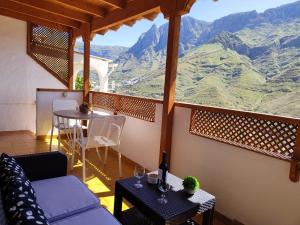San PedroにあるLa Casita de Agaeteの山の景色を望むソファとテーブル付きの客室です。