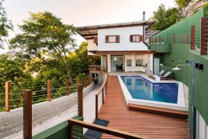 a house with a swimming pool on a wooden deck at Casa com piscina, deck e vista para o mar in Morro de São Paulo
