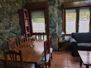 a dining room with a wooden table and chairs at El Relax de Sanabria in Trefacio